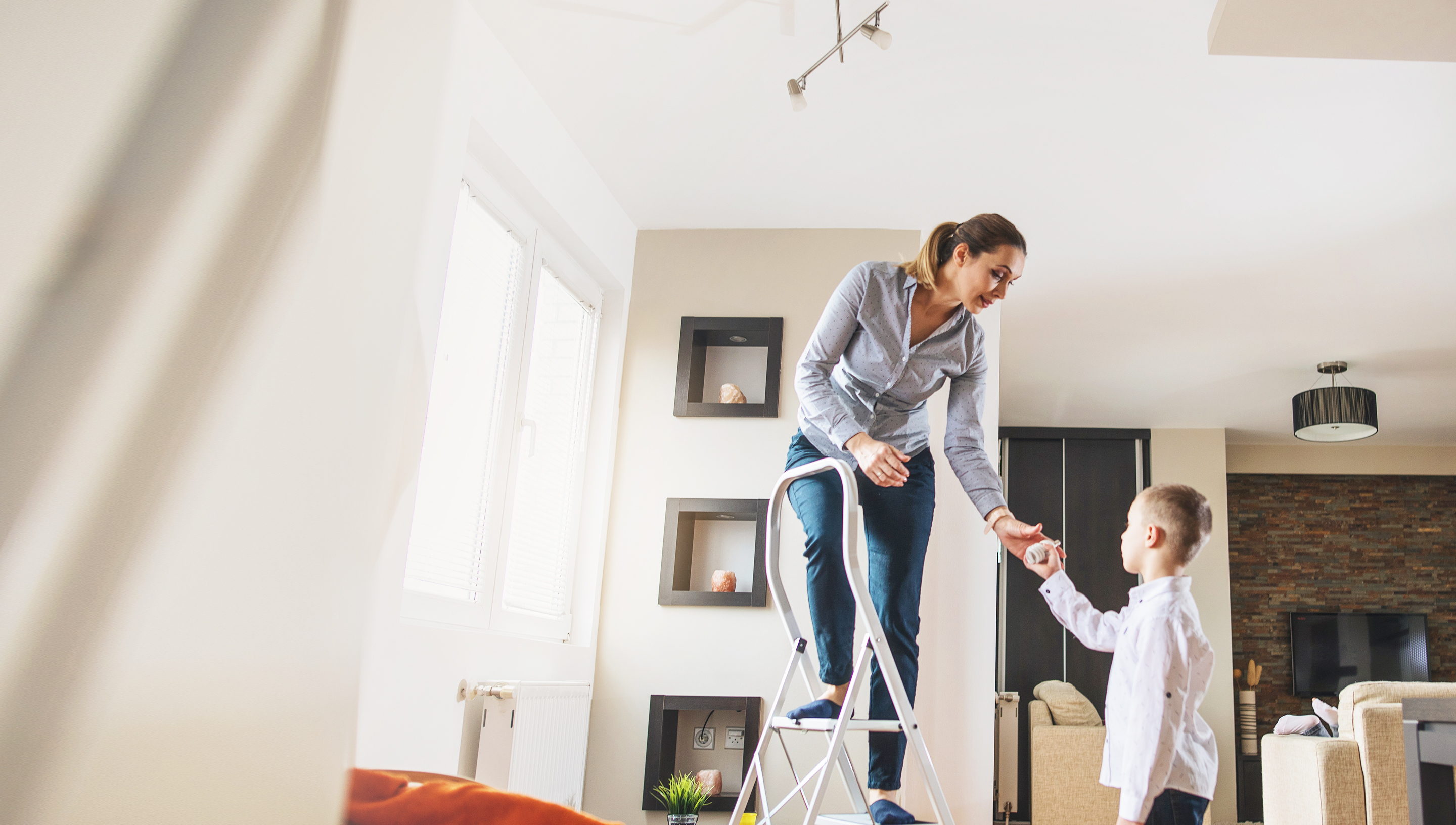 son helps mom replace a lightbulb